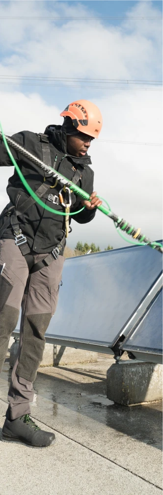 Agent Blanc SA cleaning rooftop solar panels using a safety harness